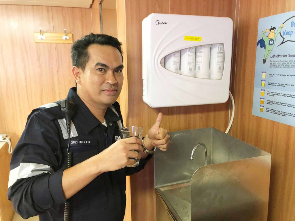 A colleague using the new water system on board